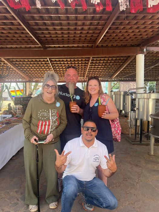 Tour group posing with their guide at a distillery