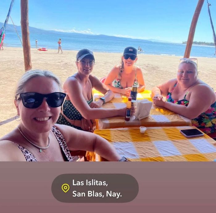 Friends enjoying lunch at a beachside table