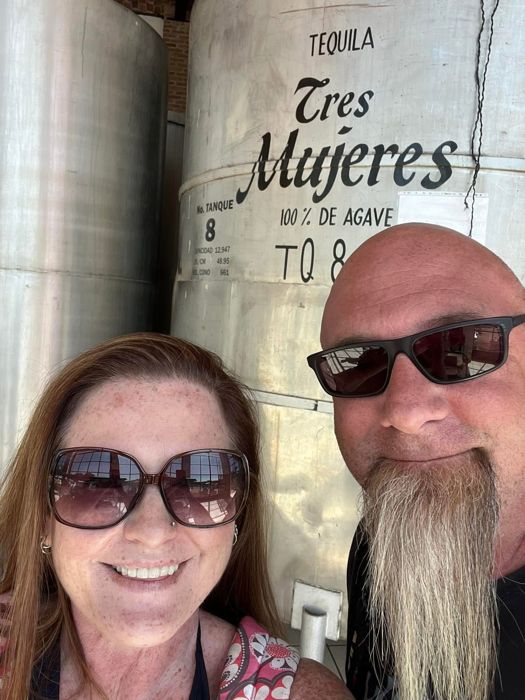 Couple taking a selfie beside tequila tanks