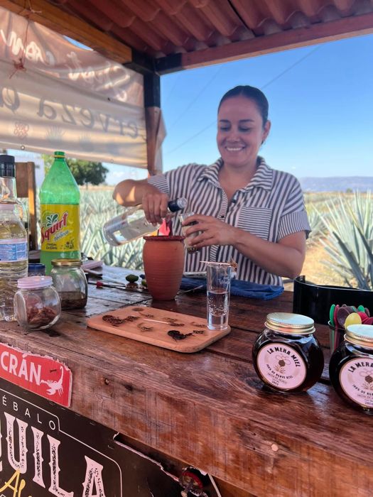 Host pouring a tasting at an outdoor tequila bar