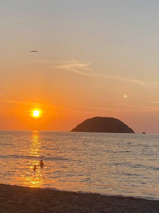 Sunset over the ocean with a small island
